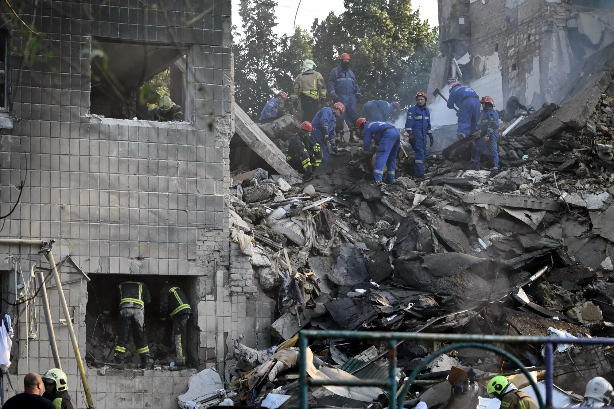 Rescuers conduct a search and rescue work in a damaged residential building following the Russian missile strike in Kyiv on June 17.