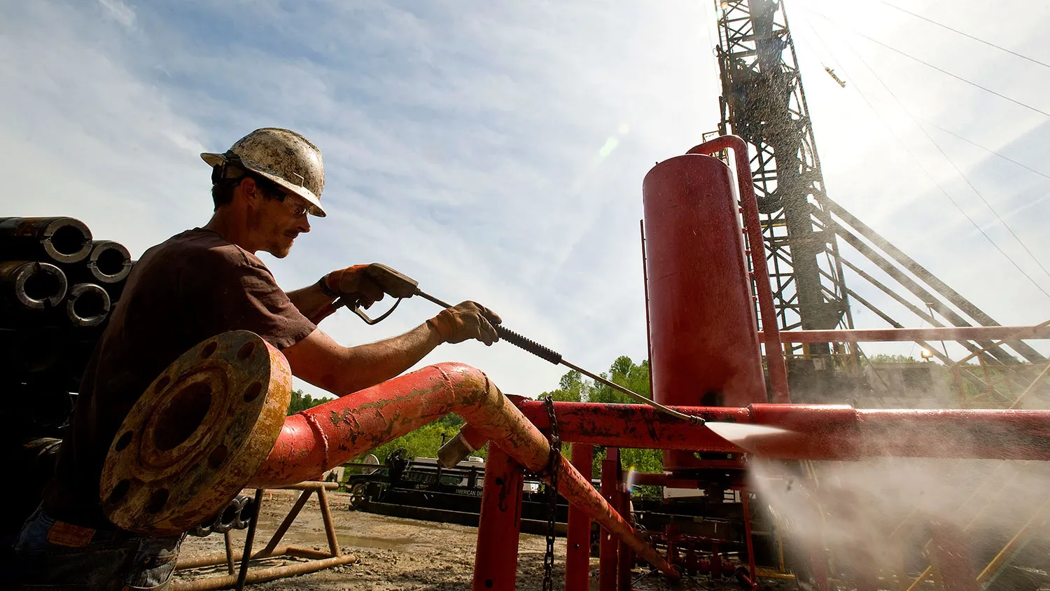 Chris Pugh, a drill hand for Horizontal Well Drillers, uses a power washer as a shale-gas well is drilled in Mannington, West Virginia, U.S., on Friday, April 30, 2010.
