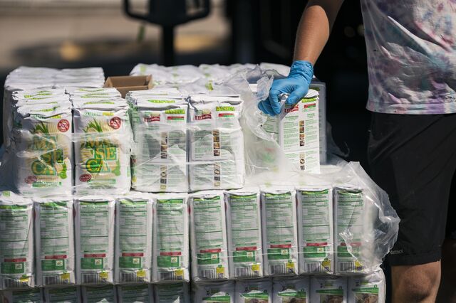 A volunteer distributes corn masa flour to local residents during a pop-up grocery event at Powderhorn Park in Minneapolis, Minnesota on July 24, 2020. 