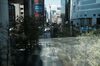 Pedestrians walking along a road are seen through a window in the Akihabara shopping district of Tokyo, Japan.