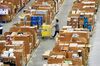 An employee pushes a trolley amongst goods at the Amazon.com Inc. fulfillment center in Hemel Hempstead, U.K., on Wednesday, Nov. 25, 2015. Wal-Mart and Amazon's toy pricing was almost equal on a three-week average leading into the holiday season, as both companies continue to provide the most competitive prices in the marketplace.