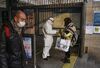 A worker takes the temperature of a woman at a subway station in Beijing on Jan. 28.