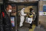 A worker takes the temperature of a woman at a subway station in Beijing on Jan. 28.