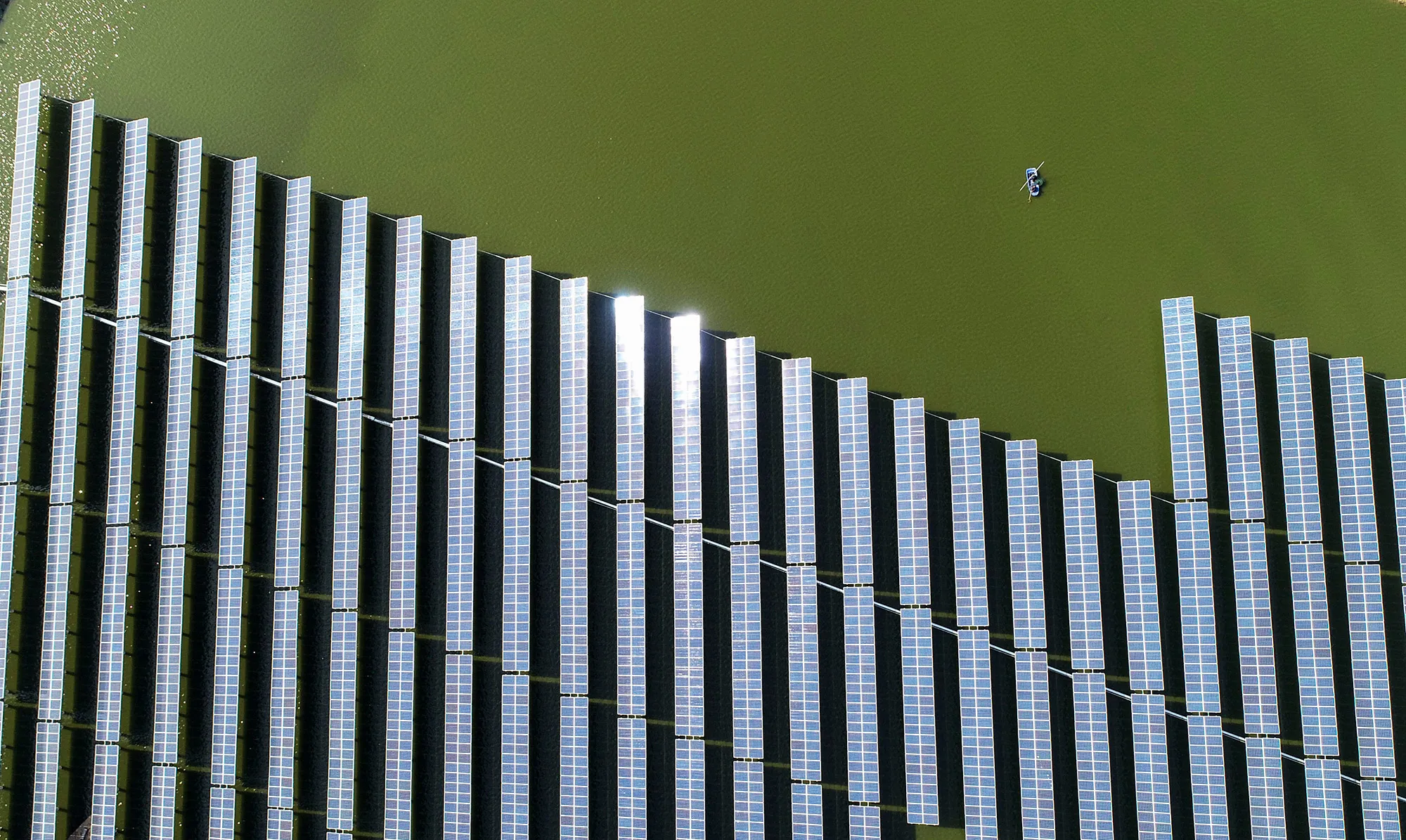 A chinese fishermen next to a solar&nbsp;station built on top of fish ponds in Yangzhou in China's eastern Jiangsu province.