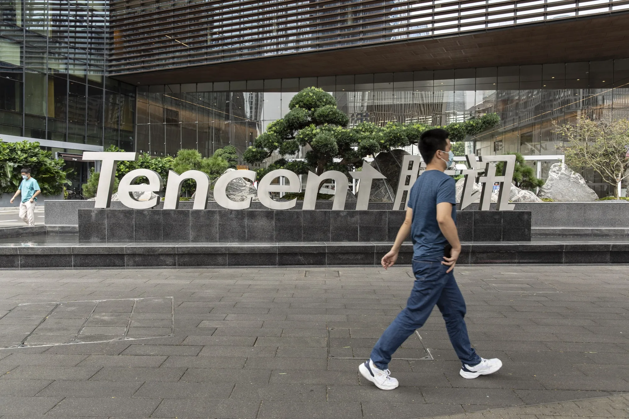 A pedestrian near signage for Tencent Holdings Ltd.&nbsp;in Shenzhen, China.