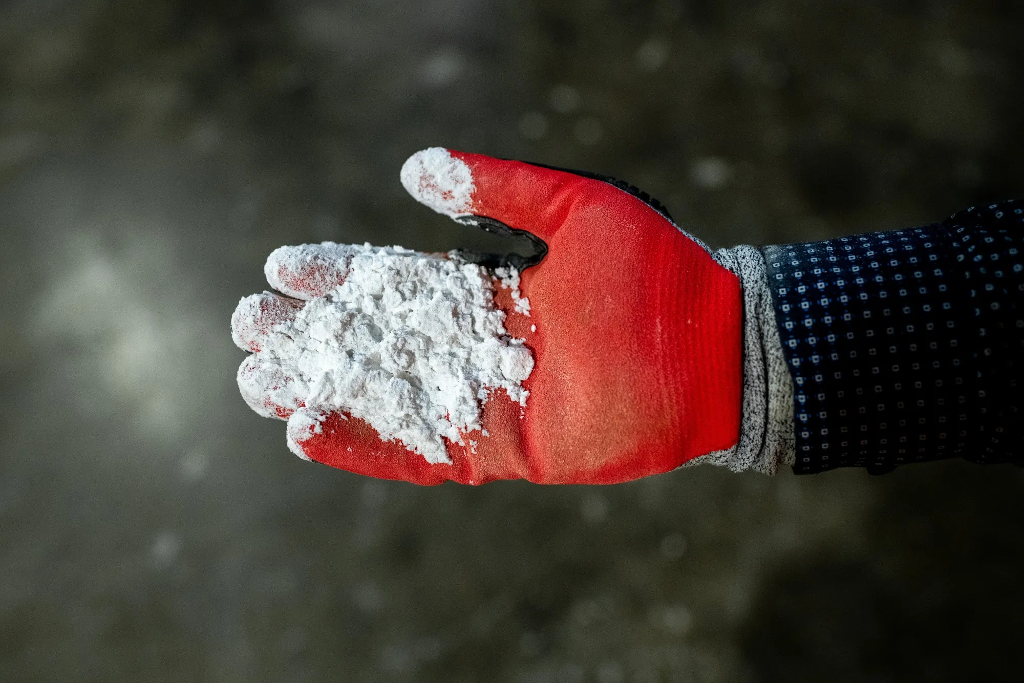 A worker holds lithium hydroxide. The material will be key to the energy transition, and a number of startups are working on new techniques to produce it.