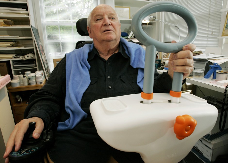 Michael Graves holds a bathtub handle he designed for disabled and elderly users.