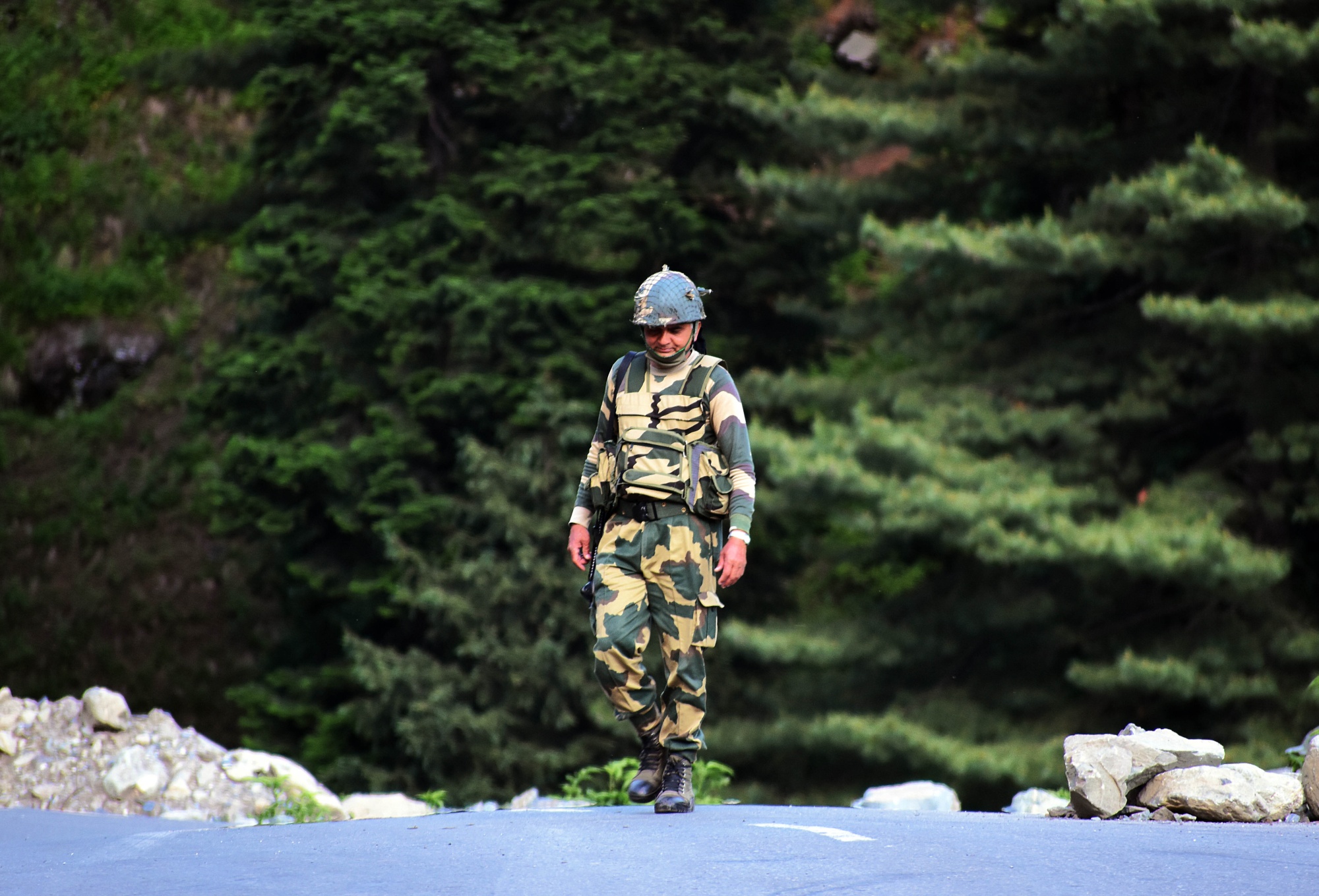 An Indian Border Security Force soldier walks near a check post along the Srinagar-Leh National highway on June 16.