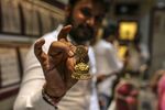 A retailer holds a gold earring at the Zaveri Bazaar in Mumbai in Nov.