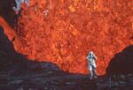 This image released by National Geographic shows Katia Krafft wearing an aluminized suit as she stands near lava burst at Krafla Volcano, Iceland, in a scene from the documentary &quot;Fire of Love.&quot; (National Geographic via AP)