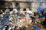 Egyptian garbage collectors and residents inspects the remains of the destroyed camp of ousted Mohammed Morsi supporters outside Rabaa al-Adawiya mosque on August 15 in Cairo