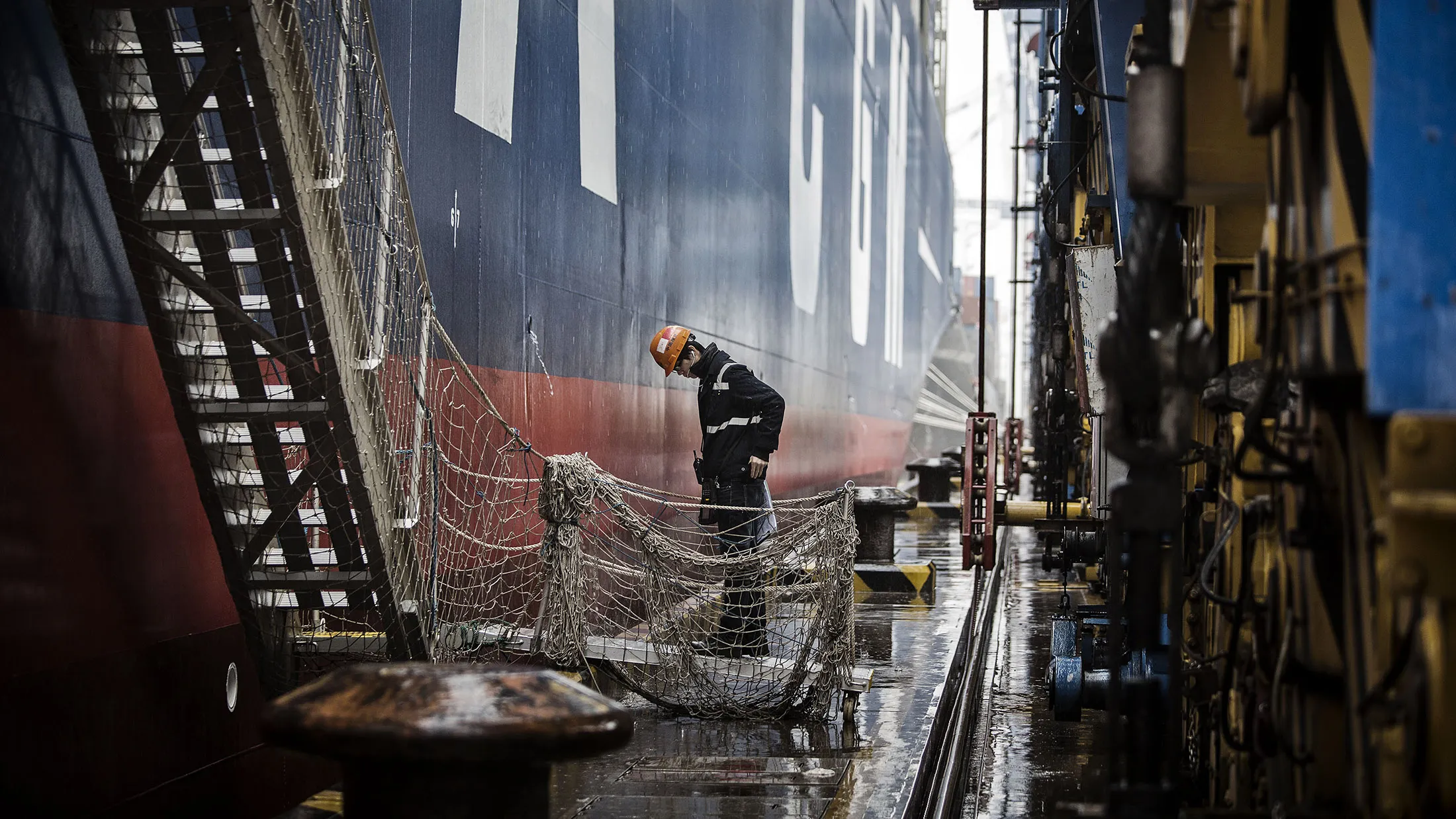 A dock worker prepares to board CMA CGM SA's Benjamin Franklin container ship docked at the Guangzhou Nansha Container Port in Guangzhou, China, on Monday, Feb. 1, 2016. The Benjamin Franklin is the largest container ship ever to have docked at a U.S. port.
