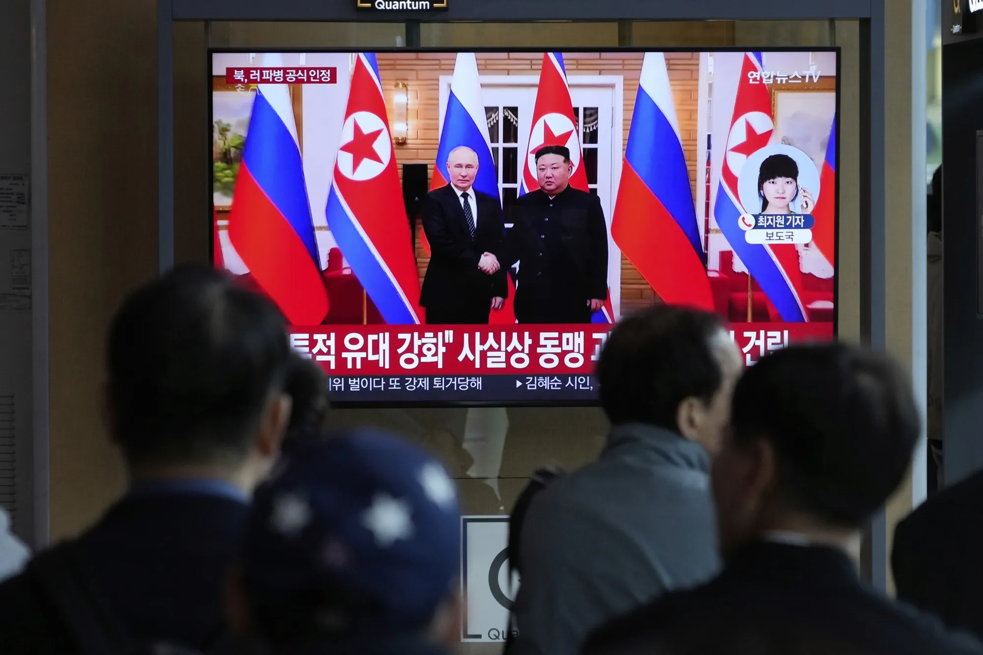 A TV screen at the Seoul Station shows a file image of Kim Jong Un, right, Vladimir Putin during a news program.