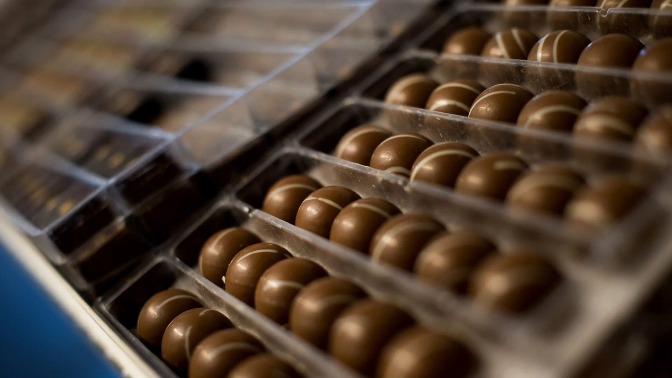 Chocolate wait to be sorted into boxes at Jacques Torres Chocolate's Brooklyn factory in New York, U.S., on Thursday, Feb. 6, 2014.
