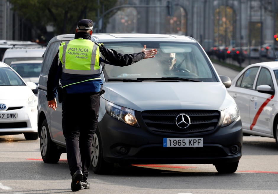 A police traffic officer stops motorists from entering the center of Madrid.