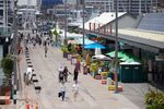 Pedestrians walk past cafes and restaurants in Auckland, New Zealand, on Dec. 5.