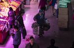 A shopper uses a bamboo pole to carry goods at a fresh food market in Shanghai, China,