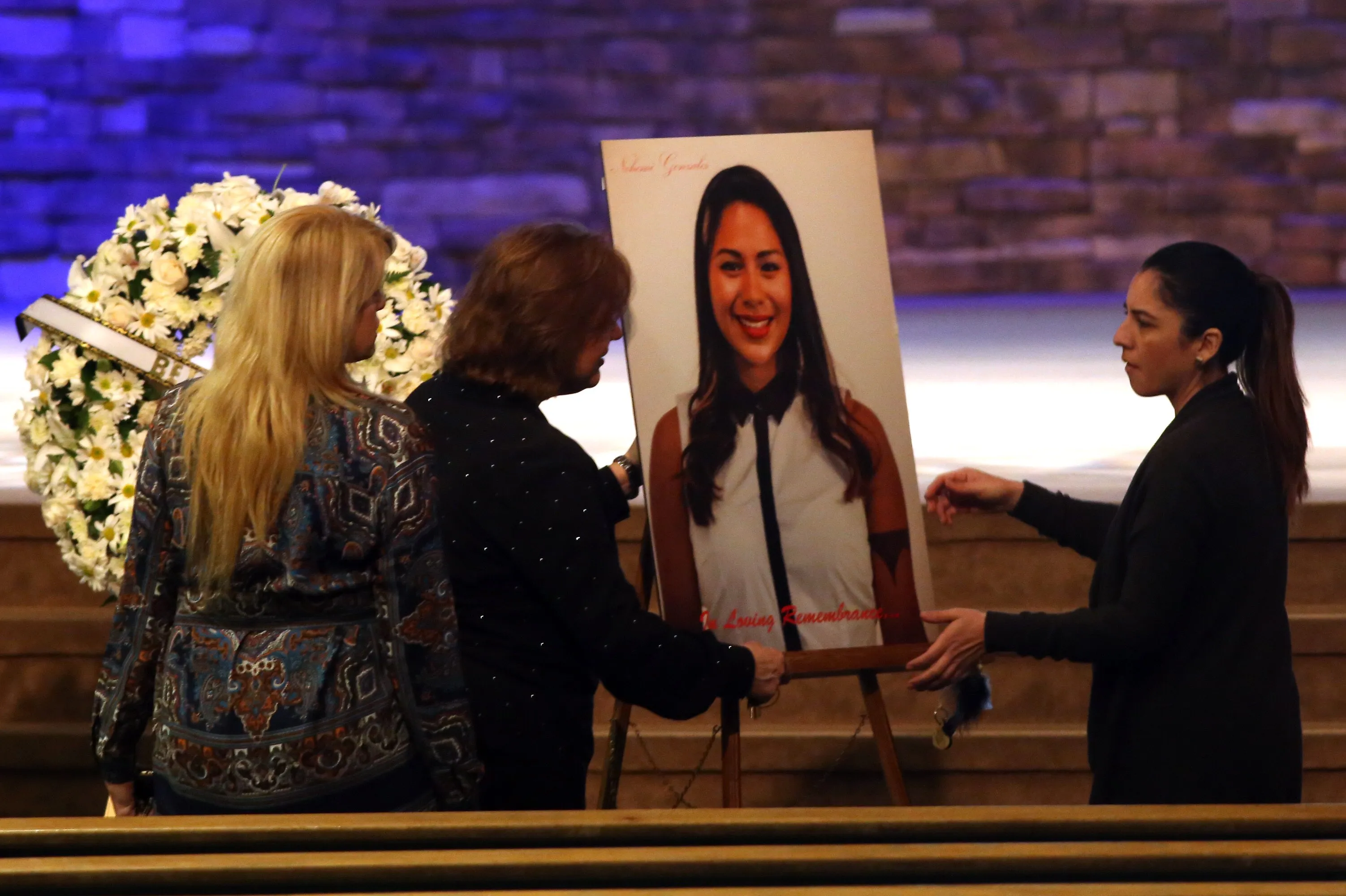 Women set up a picture of Paris terror attack victim Nohemi Gonzalez for her funeral service at the Calvary Chapel Dec. 4, 2015 in Downey, California.
