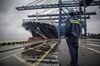 A dock worker looks at CMA CGM SA's Benjamin Franklin container ship docked at the Guangzhou Nansha Container Port in Guangzhou, China, on Monday, Feb. 1, 2016. The Benjamin Franklin is the largest container ship ever to have docked at a U.S. port.