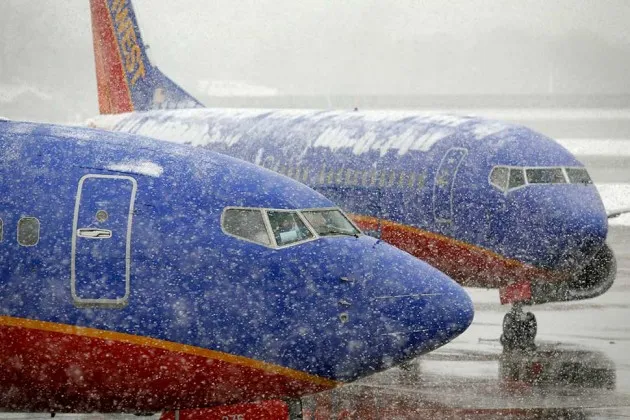 Southwest Airlines jets are seen through a thick snowfall at Love Field in Dallas