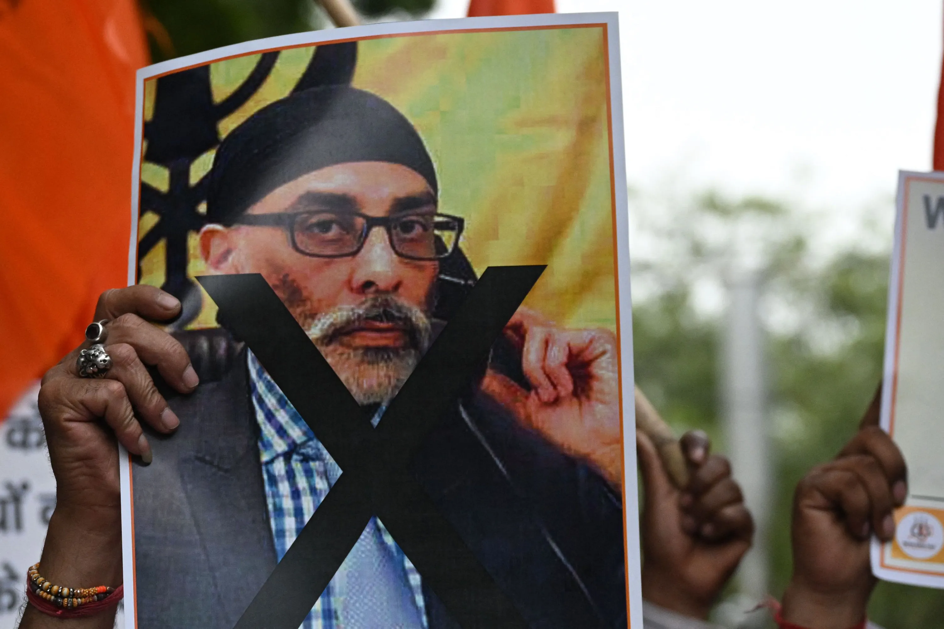 A protester holds a banner showing Gurpatwant Singh Pannun during a demonstration in New Delhi in September.&nbsp;