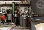 A worker checks on a dyeing machine at a raw stock dye house in Philadelphia, Pennsylvania.