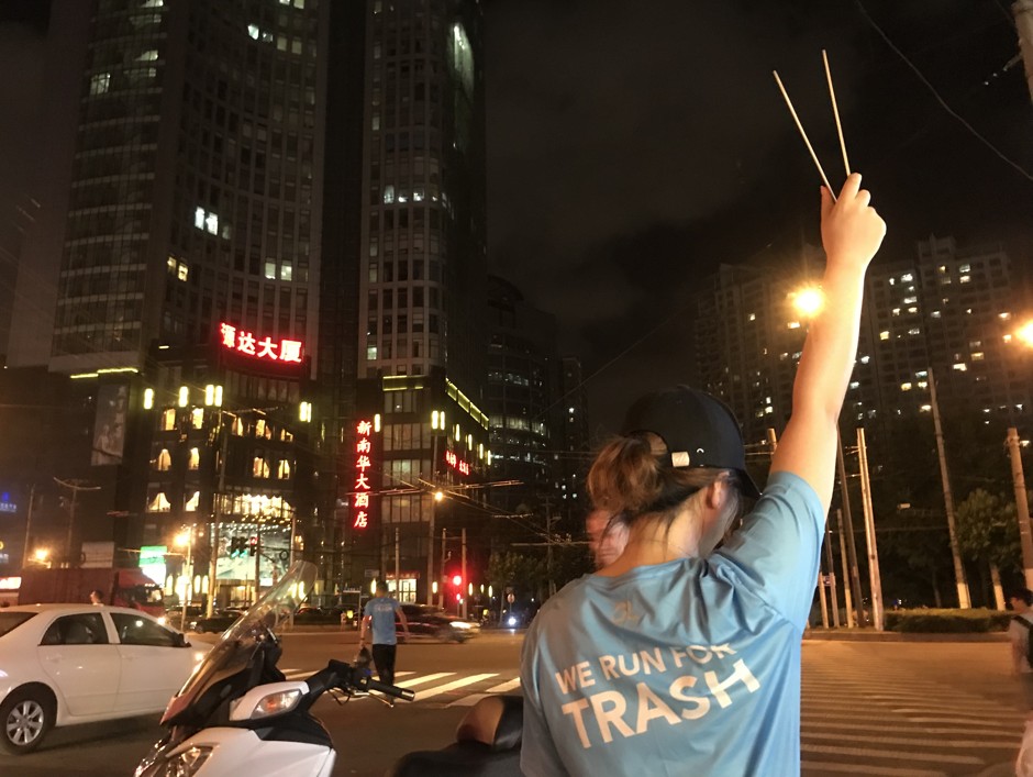 Trash runner Kerry Ding holds her tongs aloft on a July run.