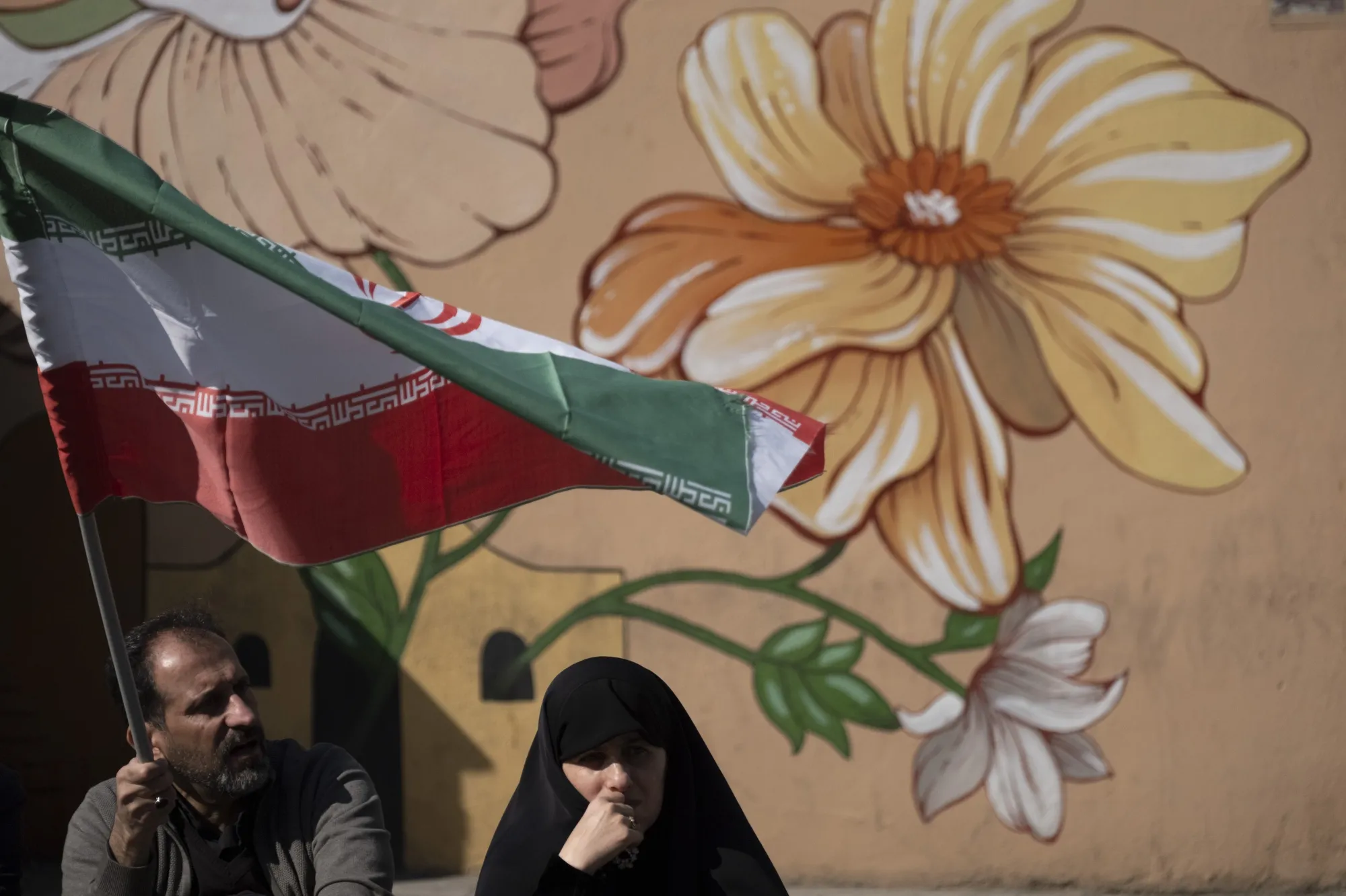 An Iranian man waves a national flag as he participates in an anti-US-Israeli rally to condemn the U.S.-Israeli military campaign in Tehran, Iran, on March 6, 2026, after Friday prayers ceremonies outside Imam Khomeini Grand Mosque.