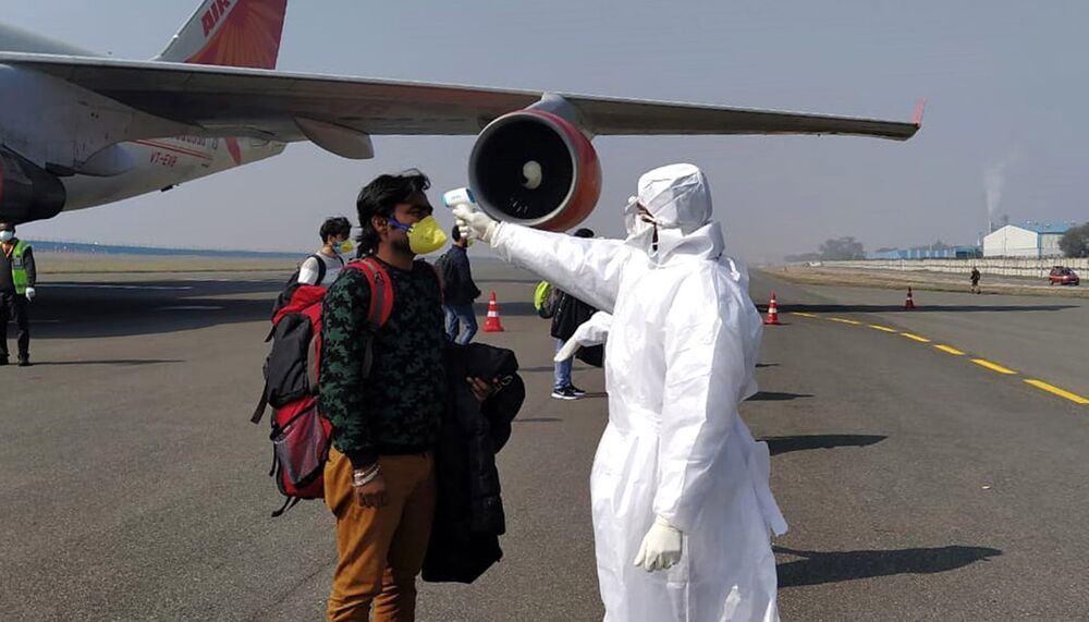 Airport health officials check the body temperature of passengers arriving from the central Chinese city of Wuhan.