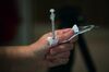 A healthcare worker unwraps a syringe while administering doses of the Pfizer-BioNTech Covid-19 vaccine in a care home in Paris, France, on Thursday, Jan. 7, 2021. A majority of French people intend to be vaccinated against Covid-19, crossing the 50% level for the first time, an Ifop-Fiducial poll showed.
