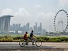 Tandem bicyclists ride their vehicle as the Singapore city skyline is seen shrouded in haze on October 9, 2015. An umbrella group of local and foreign banks in smog-hit Singapore has urged members to make "sustainable development" part of their lending requirements, stepping up pressure on companies linked to land-clearing fires in Indonesia. AFP PHOTO / ROSLAN RAHMAN (Photo credit should read ROSLAN RAHMAN/AFP/Getty Images)