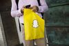 A pedestrian holds a Snap Inc. bag outside of the company's building in the Venice Beach neighborhood of Los Angeles, California, U.S.