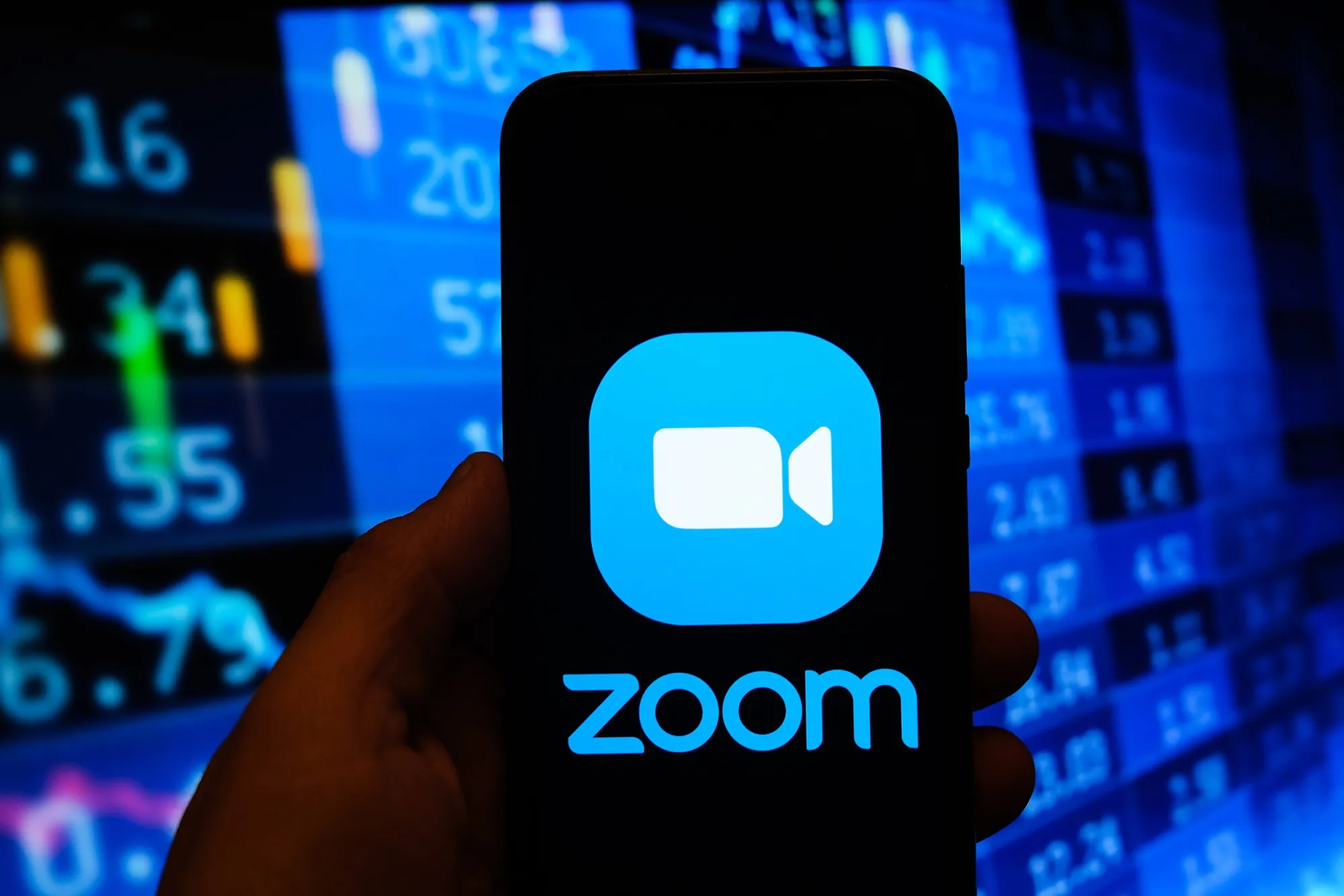POLAND - 2020/11/17: In this photo illustration a multiple exposure image shows a Zoom video logo displayed on a smartphone with stock market percentages in the background. (Photo Illustration by Omar Marques/SOPA Images/LightRocket via Getty Images)