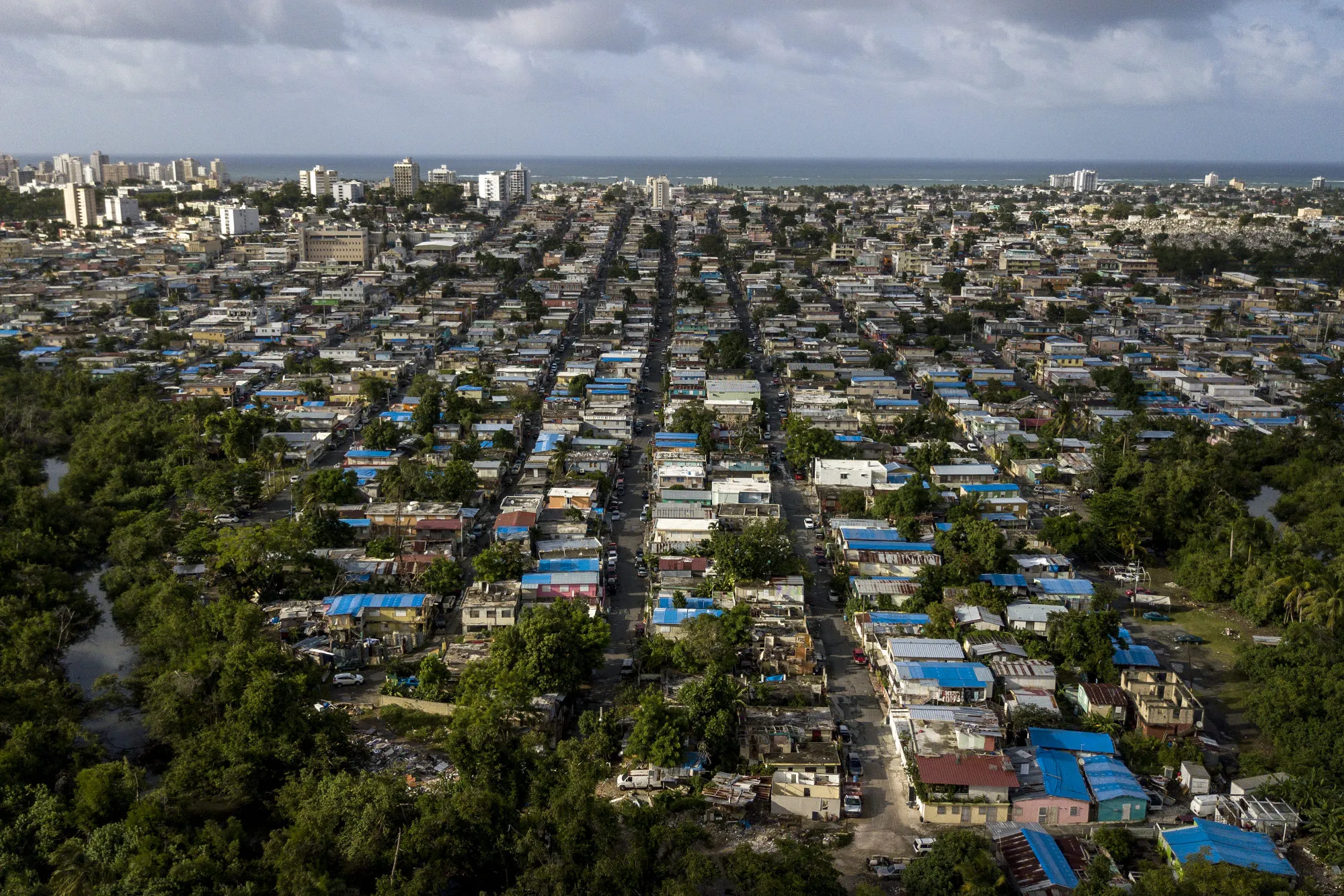 Neighborhoods in San Juan, Puerto Rico, appear as a checkerboard of blue tarpaulins that were provided by the federal government.&nbsp; A year after Hurricane Maria, the U.S. commonwealth is still laboring to recover.&nbsp;