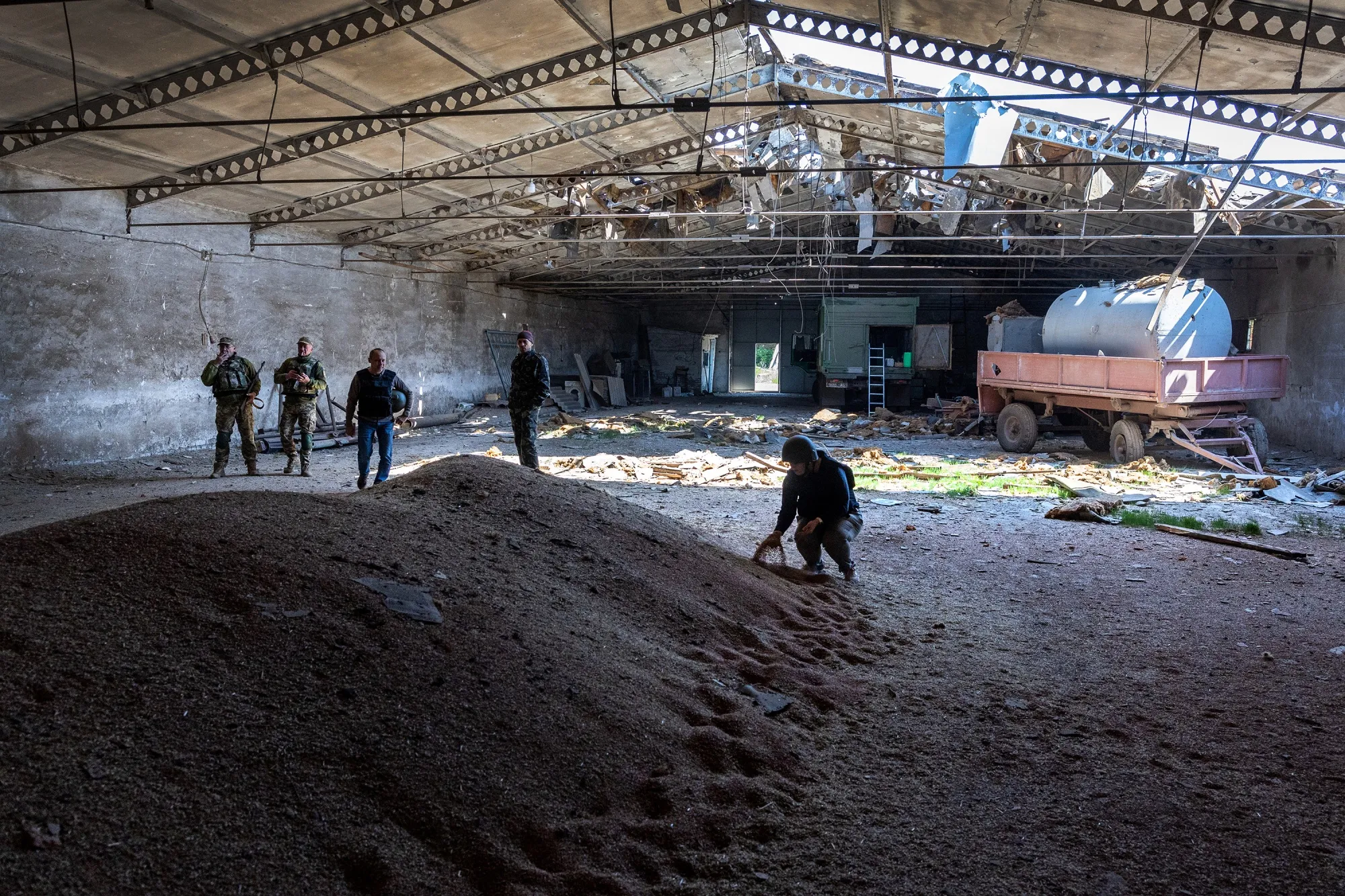 Ukrainian soldiers and officials inspect a wheat grain warehouse earlier shelled by Russian forces in Novovorontsovka, Ukraine, on May 6.