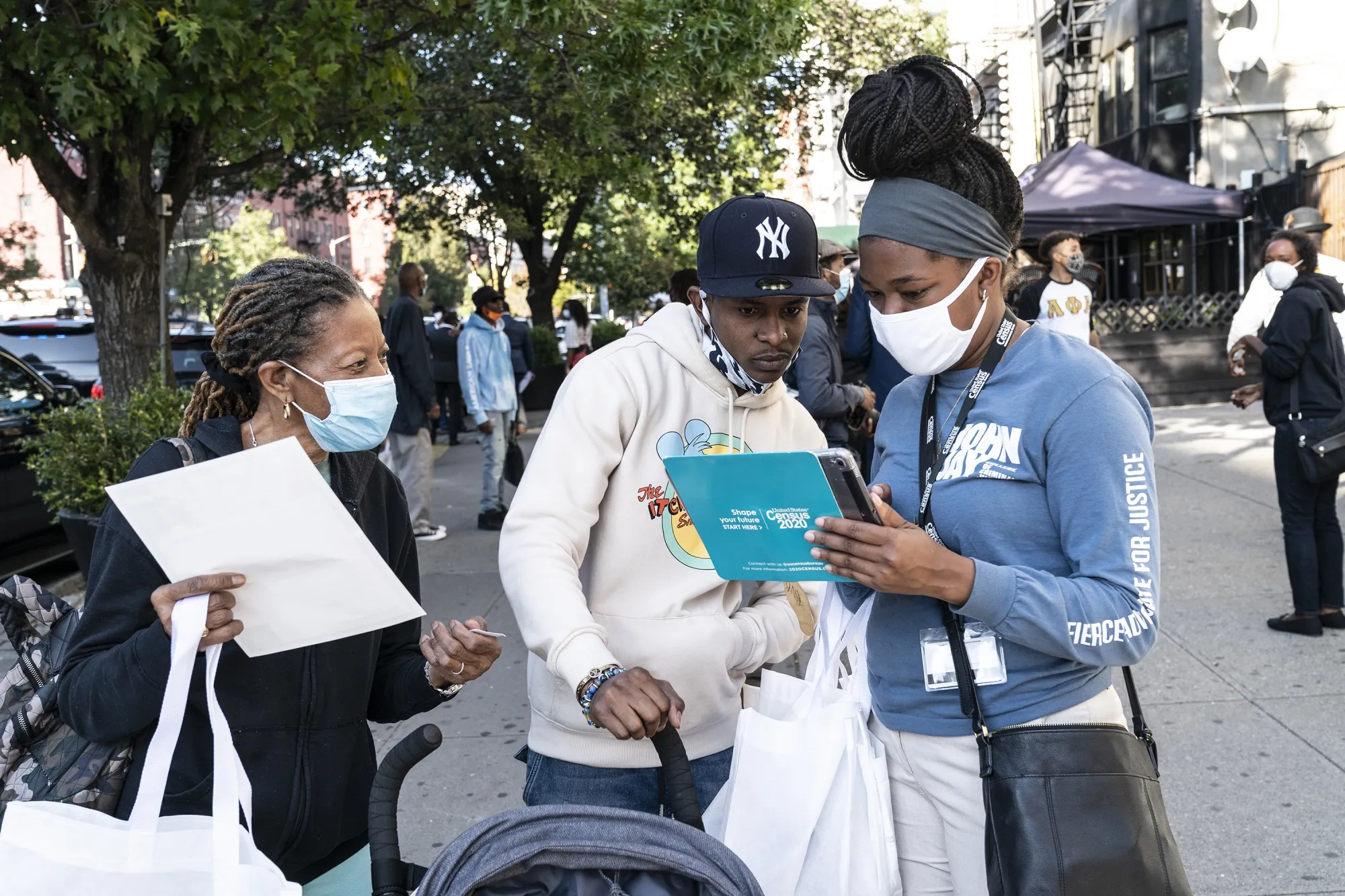 Census 2020 employees help a&nbsp;New Yorker fill out a census form at Sylvia's Restaurant in Harlem. A host of setbacks in this year’s census count could result in a severe undercount of hard-to-reach populations, experts warn.&nbsp;