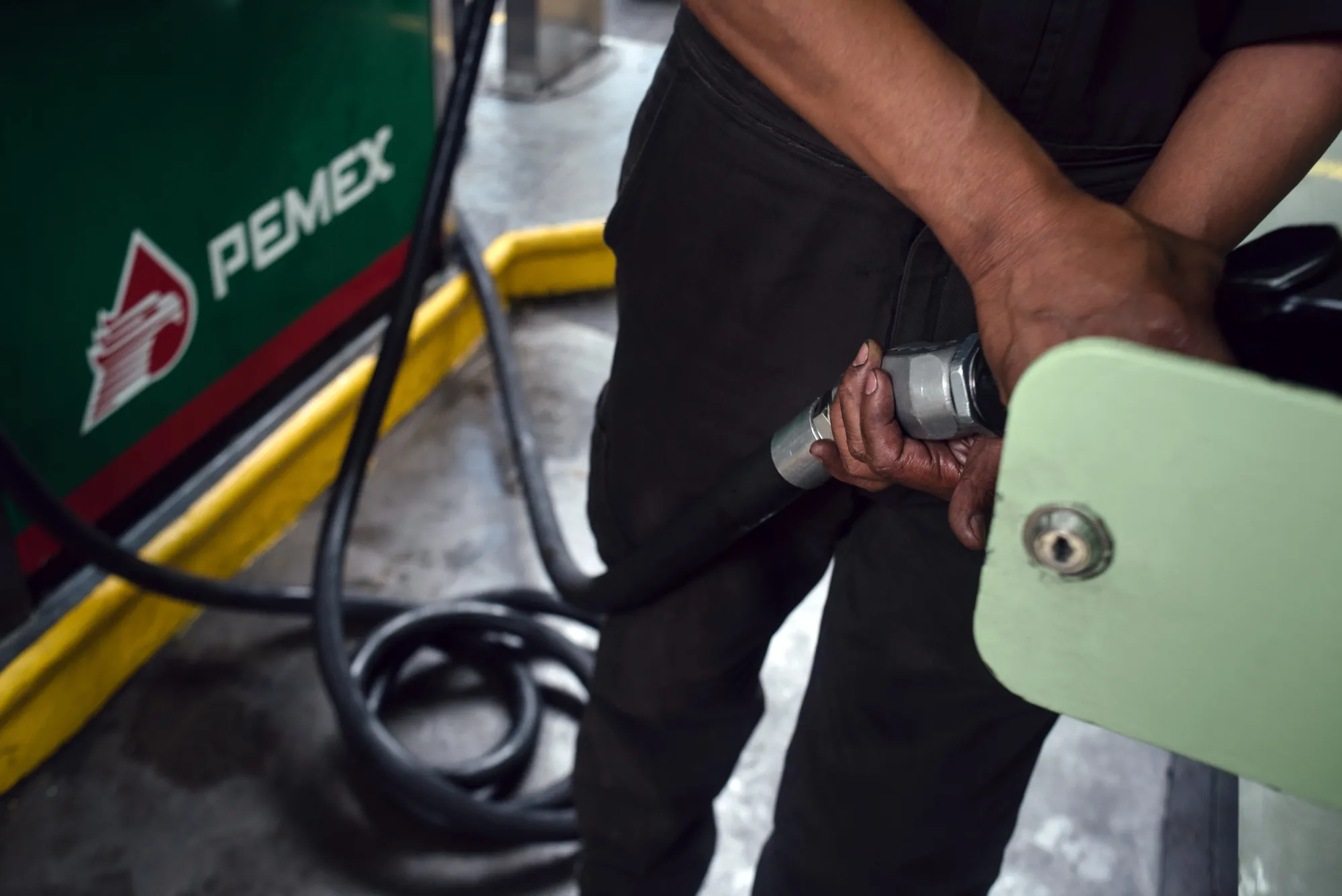 An attendant fuels a bus at a Petroleos Mexicanos (Pemex) gas station in Mexico City, Mexico.