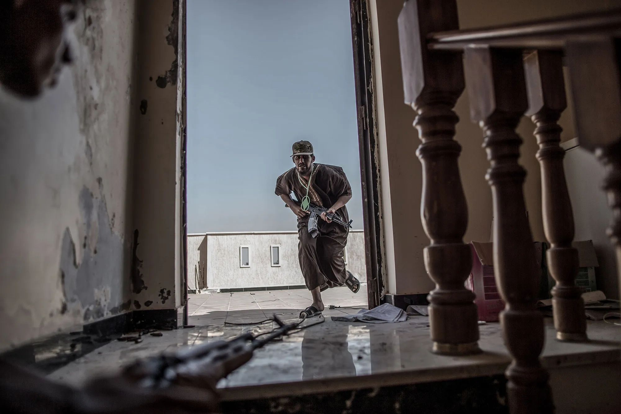 A fighter of Libya's UN-backed Government takes cover from enemy fire during clashes.&nbsp;