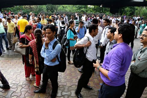 People stand outdoors after they rushed out of their offices following tremors in Kolkata, India, on Wednesday, Aug. 24, 2016. Officials say a powerful earthquake measuring a preliminary magnitude of 6.8 has shaken central Myanmar.
