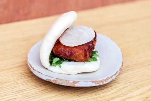 The crumbed daikon bao is served with daikon pickle, hot sauce, and coriander.
