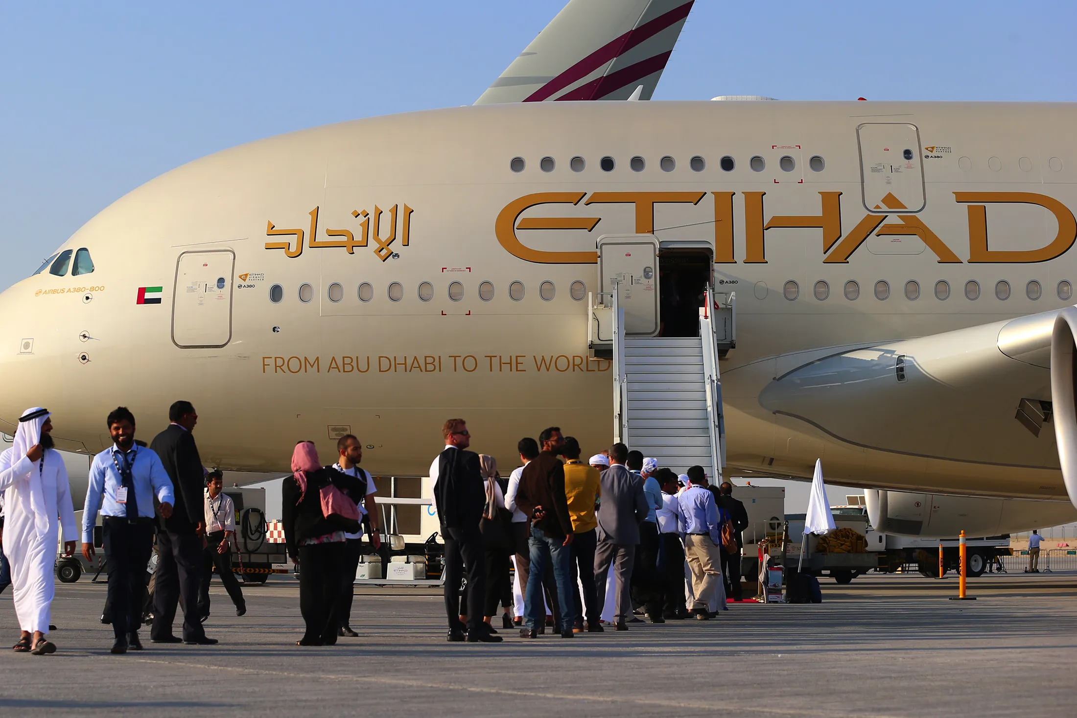 Visitor queue to access an Airbus A380-800 aircraft, operated by Etihad Airways, on the second day of the 14th Dubai Air Show at Dubai World Central (DWC) in Dubai, United Arab Emirates, on Monday, Nov. 9, 2015. The Dubai Air Show is the biggest aerospace event in the Middle East, Asia and Africa and runs Nov. 8 - 12.

