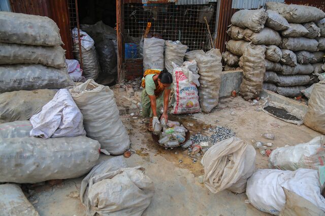A worker washes medical bottles collected from the Matuail Sanitary Landfill in Dhaka