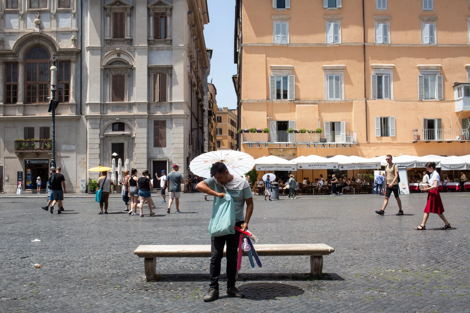 A vendor sells parasols for the sun and electric fans during hot weather caused by the Charon heat wave, in Rome, earlier in July.&nbsp;