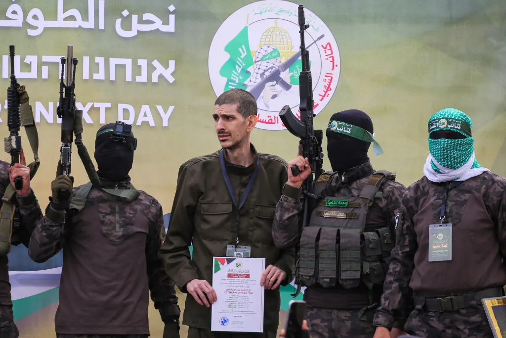 Palestinian Hamas fighters escort Eli Sharabi on a stage before handing him over to a Red Cross team in Deir el-Balah, central Gaza, on Feb.&nbsp;8.