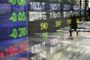 A pedestrian wearing a protective mask is reflected in an electronic stock board outside a securities firm in Tokyo, Japan, on Monday, Jan. 4, 2021. Asian stocks climbed to a new record, as technology shares remained strong in the first session of 2021.