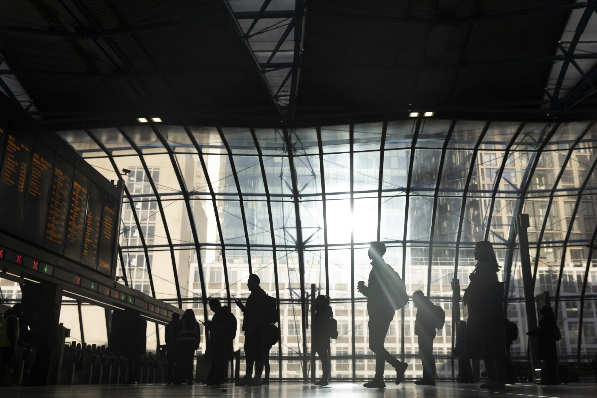 Commuters view departure boards on a railway concourse&nbsp;at London Waterloo railway station.