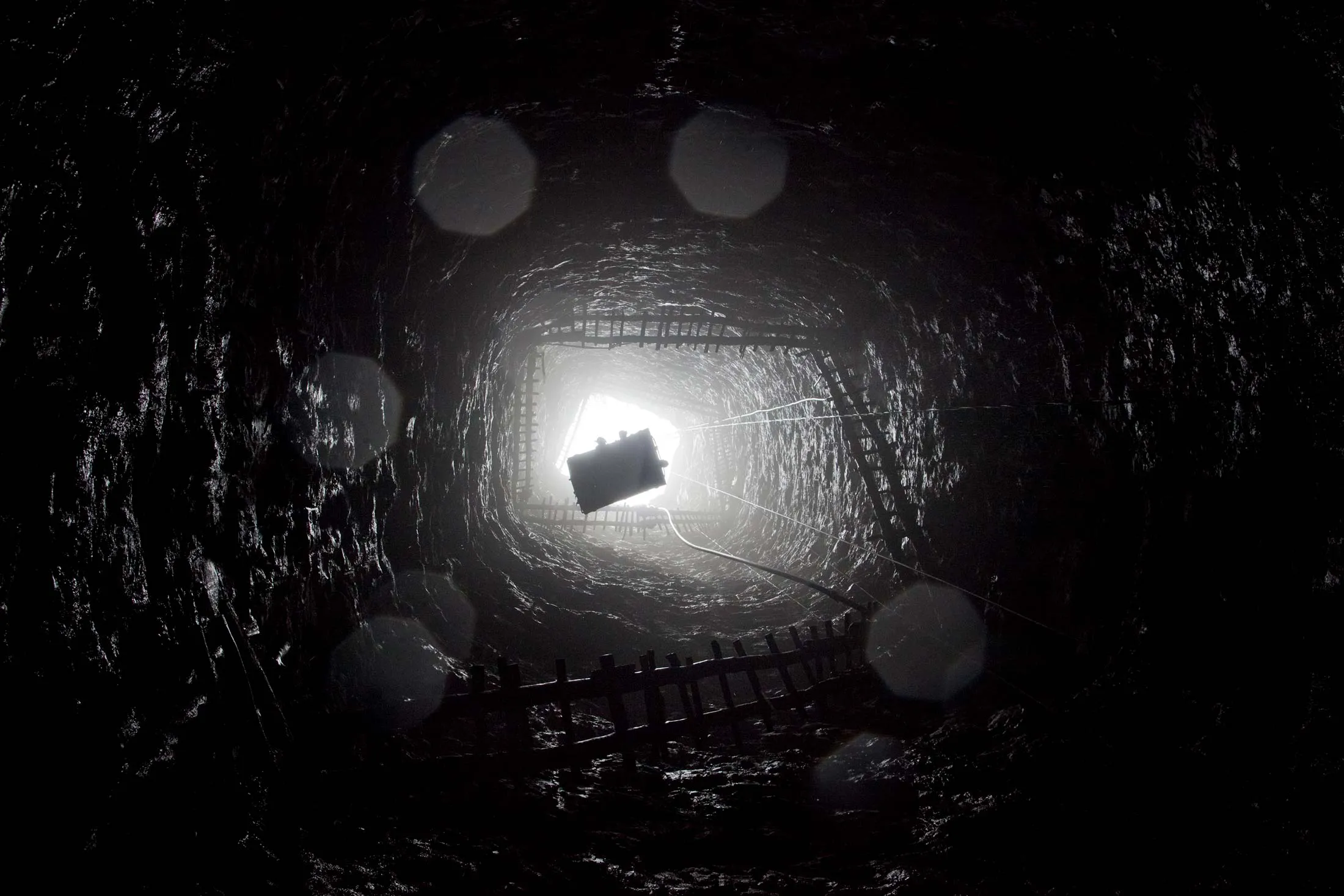A crane lifts workers from the depths of a coal shaft in India. Energy developers around the globe&nbsp;are pushing to transform abandoned mines into hydroelectric storage facilities to stockpile wind and solar power.&nbsp;
