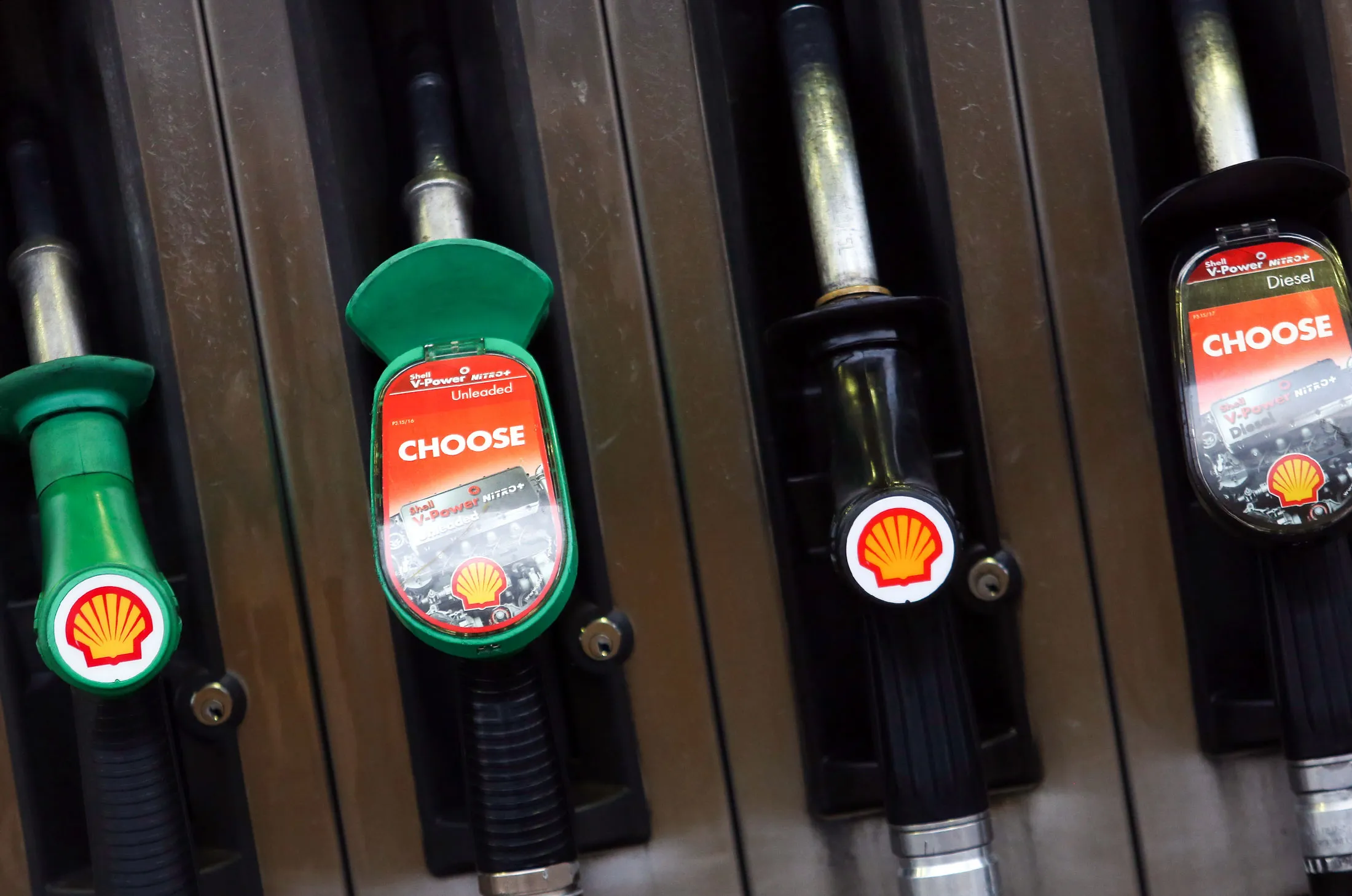 Unleaded and diesel petrol pumps sit holstered at a Royal Dutch Shell Plc gas station in Brentwood, U.K., on Wednesday, Jan. 20, 2016. Shell, which is buying BG Group Plc in the industry's largest deal in a decade, expects fourth-quarter profit to drop at least 42 percent after the rout in crude prices deepened.
