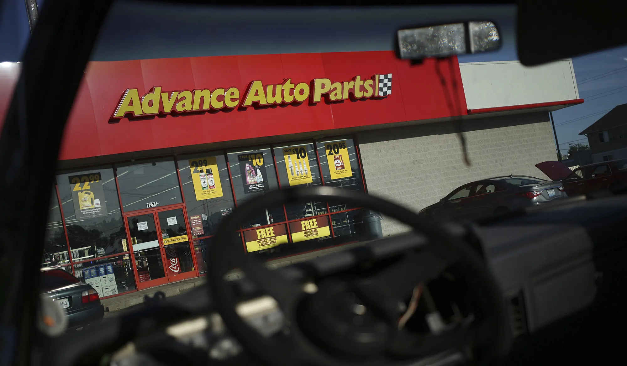Customer vehicles sit parked outside an Advance Auto Parts Inc. automotive supply store in Frankfort, Kentucky.