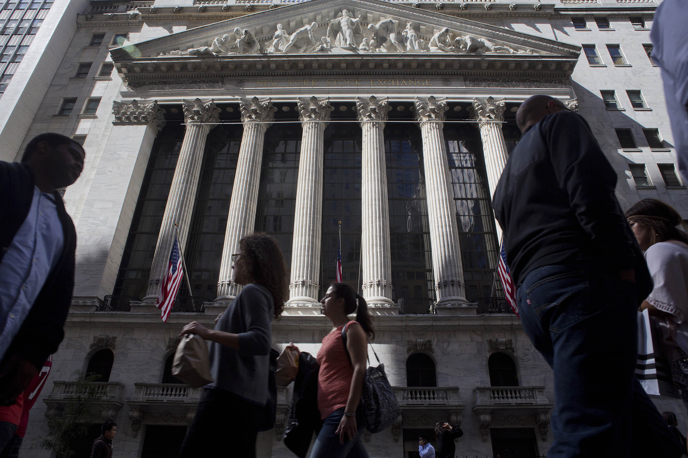 Pedestrians pass by the New York Stock Exchange (NYSE) in New York, U.S., on Friday, Sept. 26, 2014. The S&amp;P 500 finished the quarter below its average price for the past 50 days after dropping under that level for the first time since August on Sept. 25.
